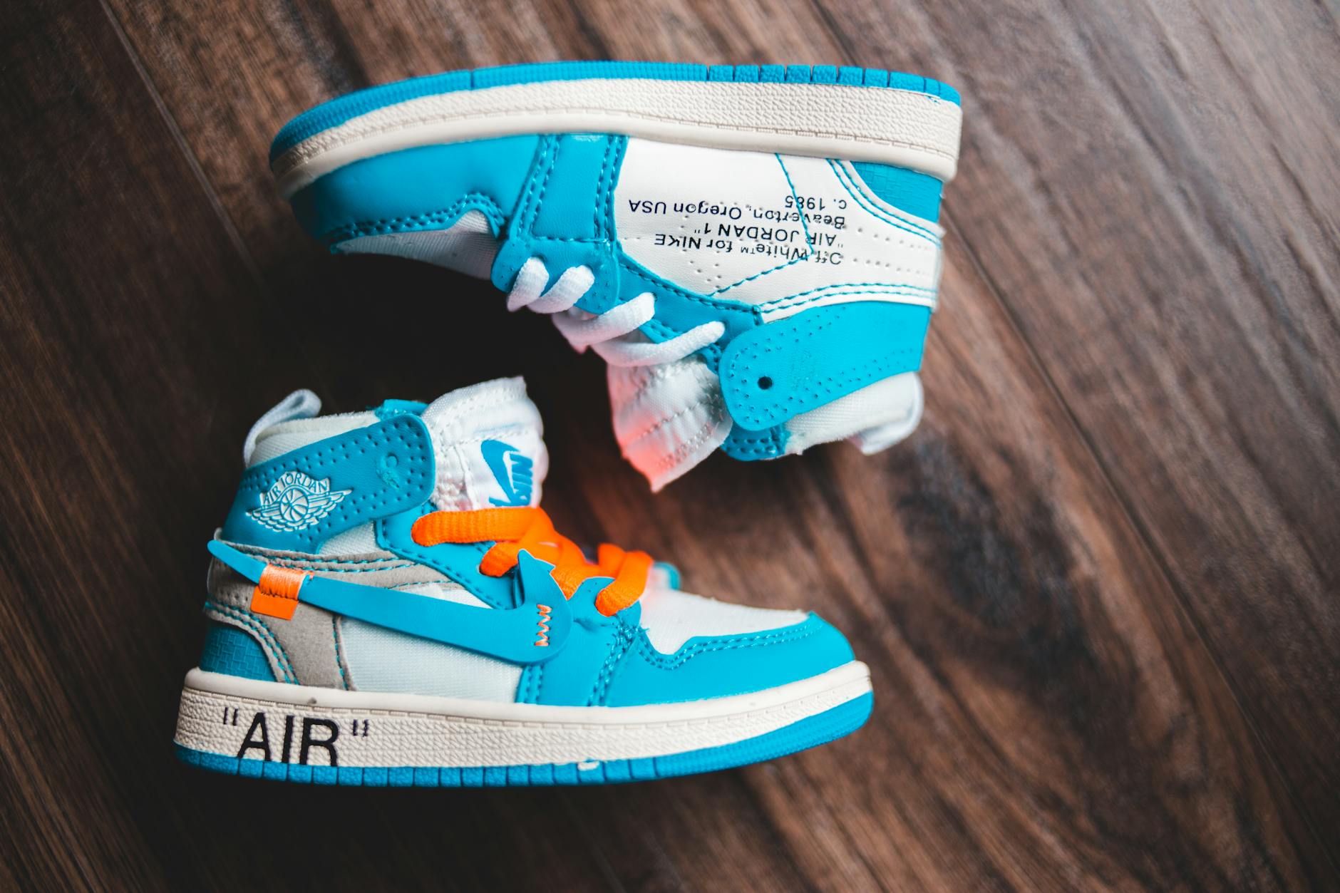 pair of baby sneakers on wooden floor